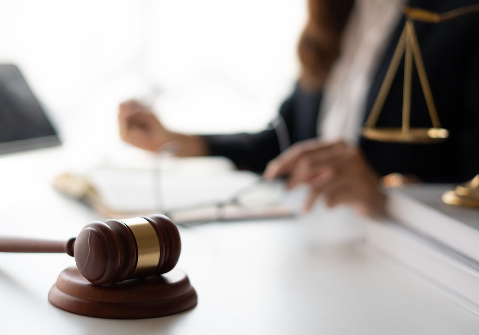 Attractive young lawyer in office Business woman and lawyers discussing contract papers with brass scale on wooden desk in office. Law, legal services, advice, Justice and real estate concept.
