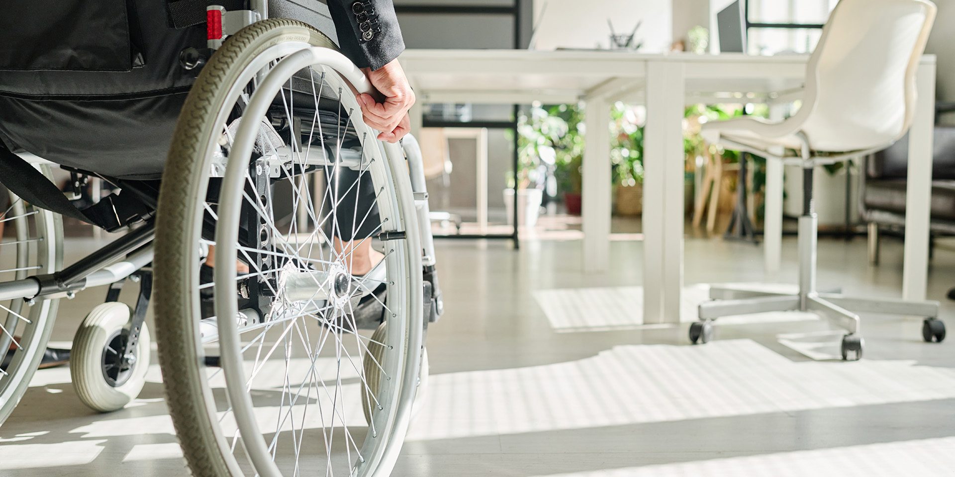 Close-up of office worker with disability sitting in wheelchair while working at office